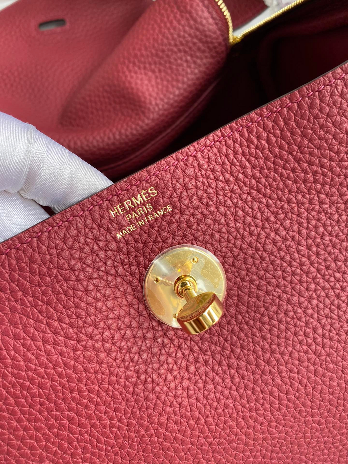 SWORD LUXURY Hermès Lindy 26 çanta, altın rengi metal detaylı ve dokulu kırmızı Clemence deri iç mekan detayı.