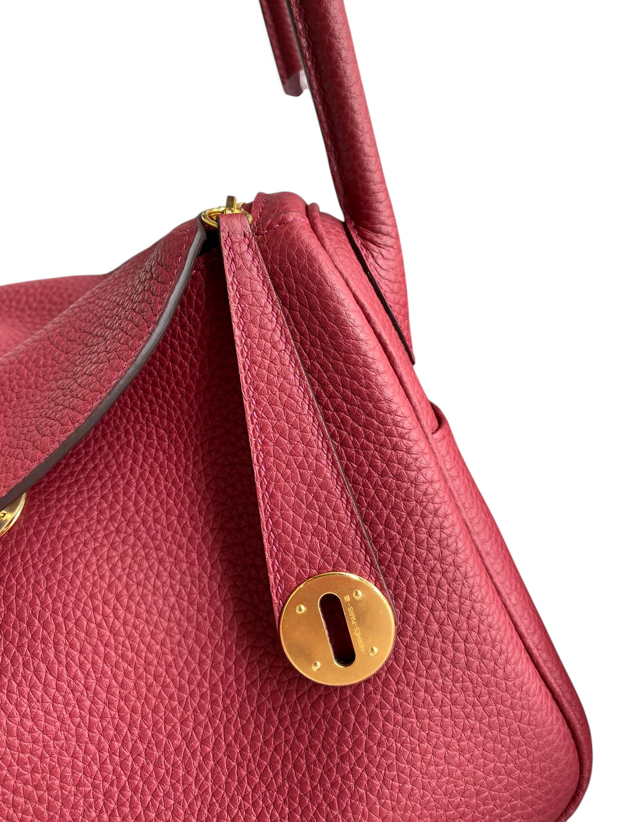 SWORD LUXURY Hermès Lindy 26 çanta, kırmızı Clemence deri dokusu ve altın rengi metal detaylarıyla yakın çekim.
