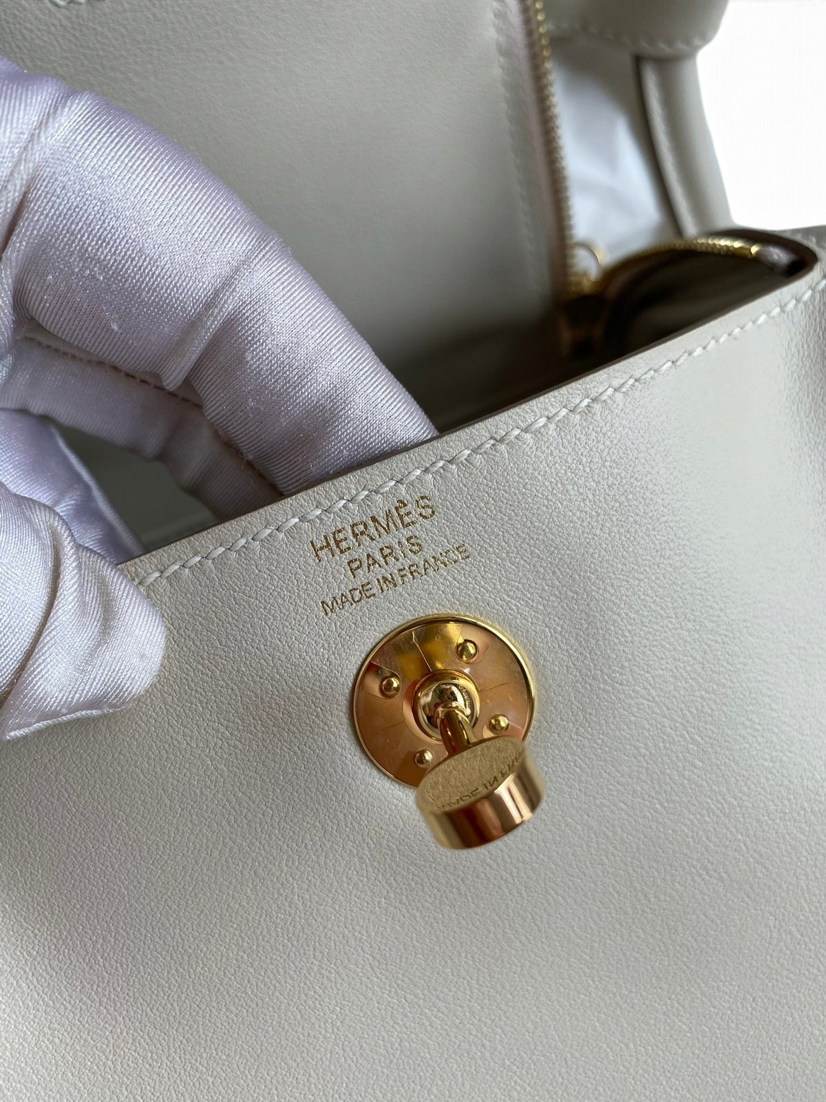 SWORD LUXURY Hermès Lindy 19 çanta, altın rengi döner kilit detayı ve deri dokusu ile yakın çekim.