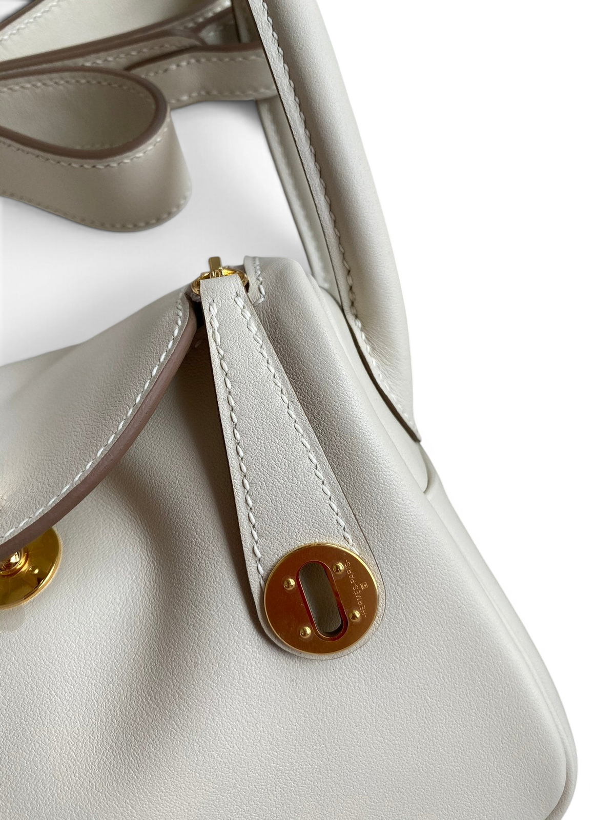 SWORD LUXURY marka, beyaz Clemence deri Hermès Lindy 19 çanta, altın rengi metal detaylı ve zarif dikişli tasarım.