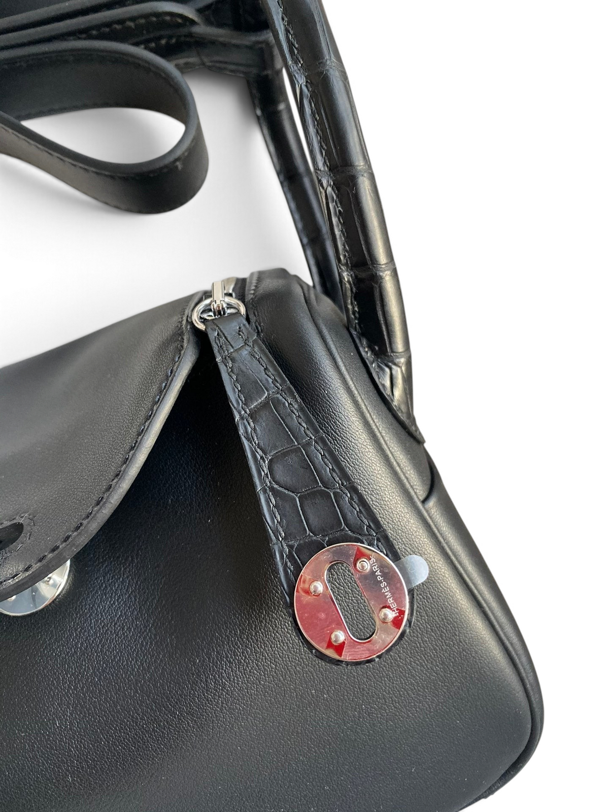 SWORD LUXURY siyah deri Hermès Lindy 19 çanta, timsah derisi detaylı sapı ve gümüş renkli metal kilit mekanizması.